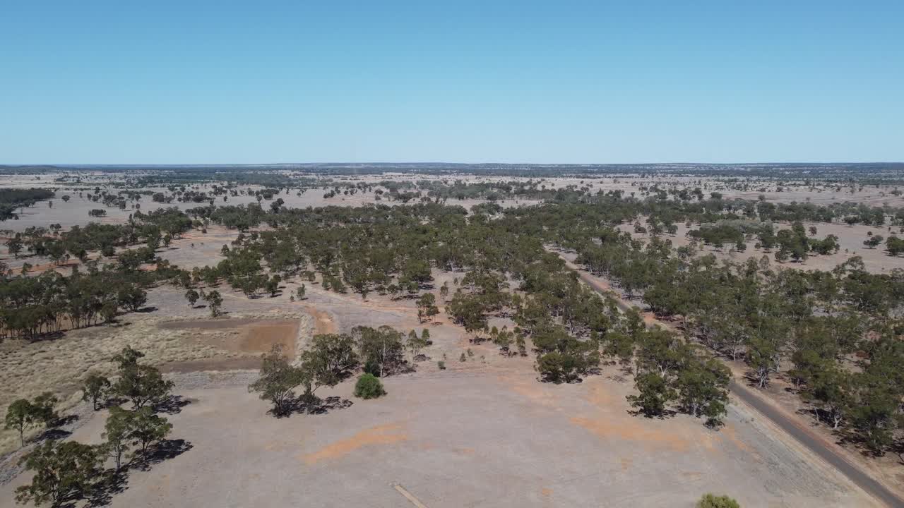 드론이 사막 스타일의 숲과 시골 도로를 날아다니고 있습니다.