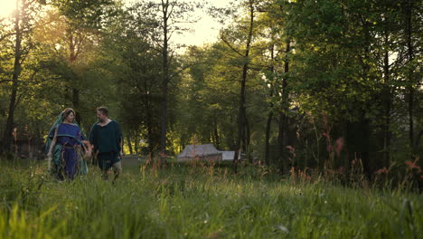 couple walking through a forest at sunset