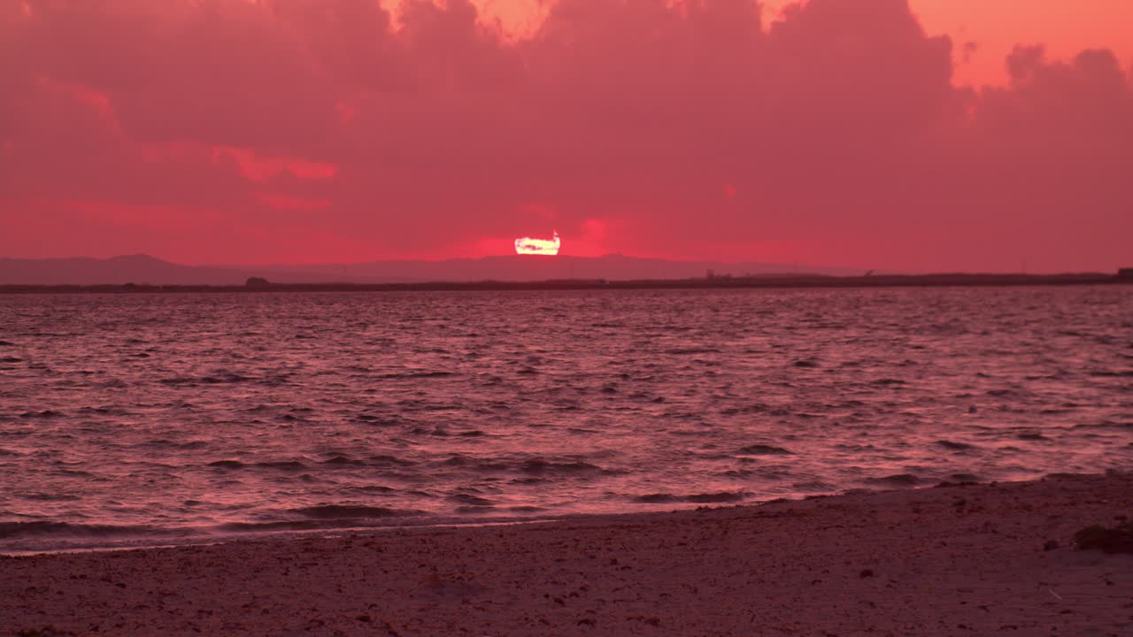 удивительный розовый закат на морском пляже, волны разбиваются о песчаный берег, увеличение