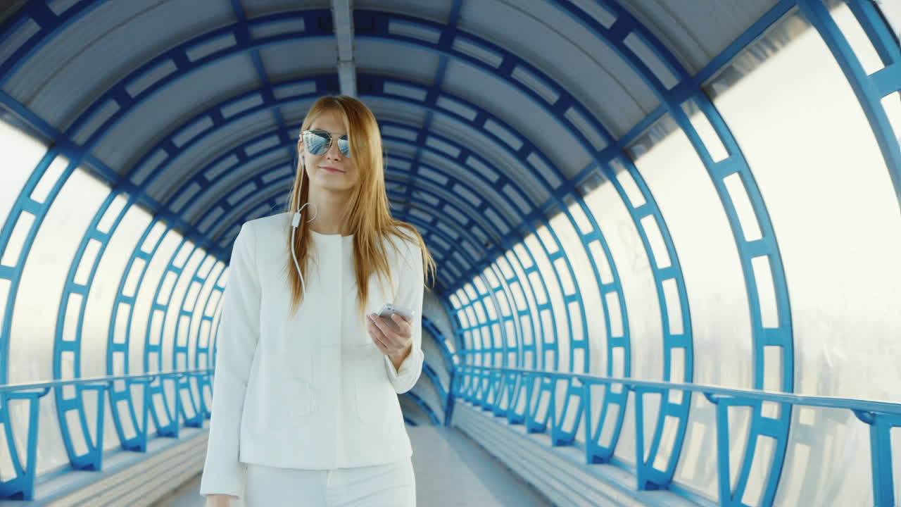 흰색 정장을 입은 세련된 비즈니스 여성은 터널을 통과하거나 유리 럭키에서 전환합니다.