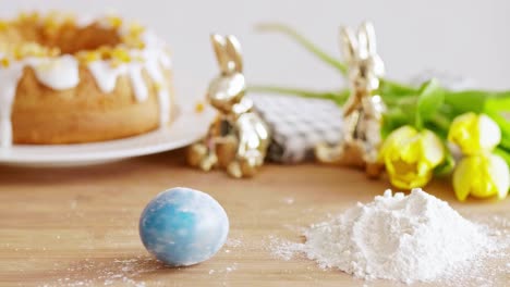 huevo de pascua y harina en la mesa de madera