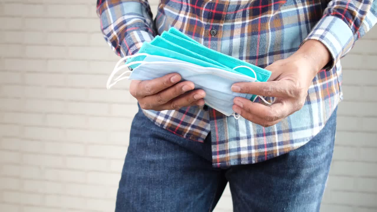 얼굴 마스크 한 어리를 들고 있는 사람