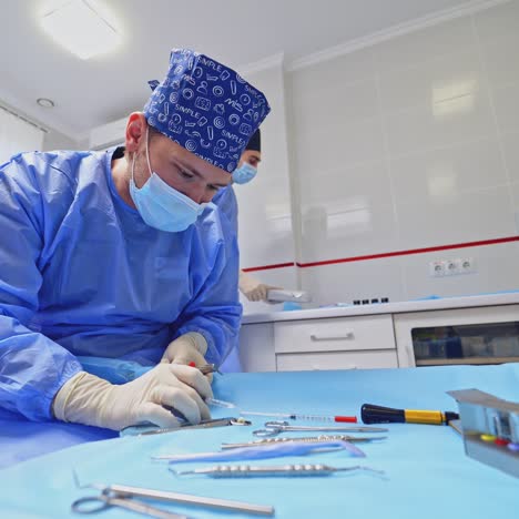 doctor and assistant with dental instruments. dentist in mask prepares medical tools before work. medical equipment on the table.
