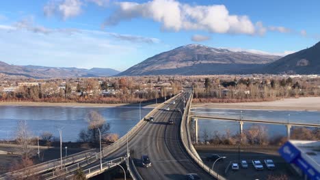 pan up shot of cars driving over the overlanders bridge in kamloops, british columbia on a sunny morning