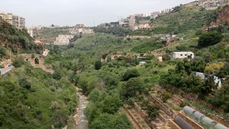 Drone-Flying-In-Middle-Valley-Of-Roman-Aqueducts-Of-Zbeideh-Village,-Lebanon