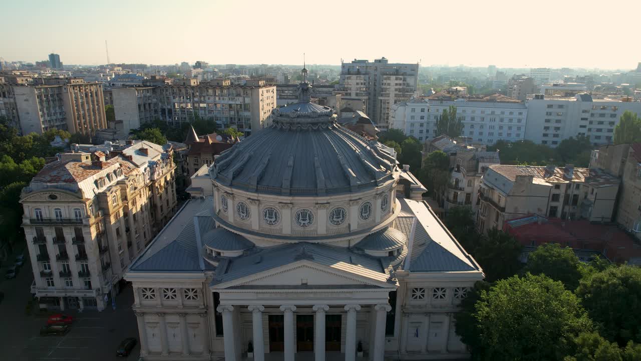 vista desde arriba sobre el ateneo rumano al amanecer en bucarest rodeado de edificios altos e históricos
