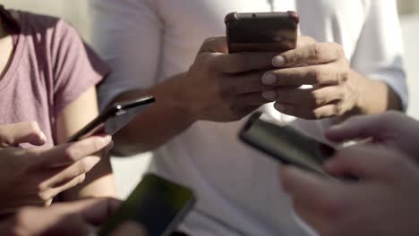 closeup shot of young people with smartphones on street