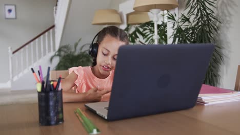 Biracial-boy-learning-online-using-laptop-at-table,-slow-motion