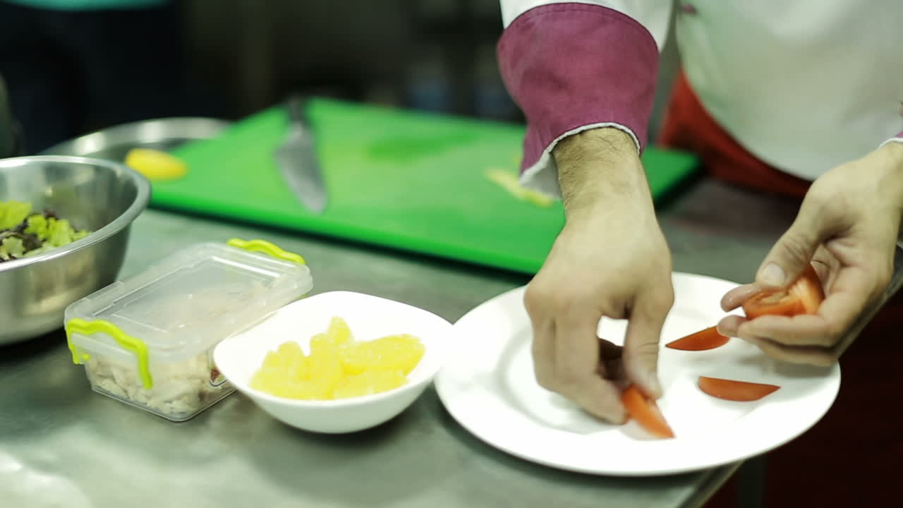 Chef Preparing Salad In Kitchen. Busy chef at work in the restaurant kitchen