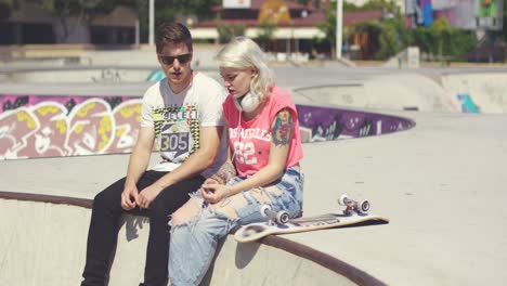 joven pareja de patinadores sentados charlando