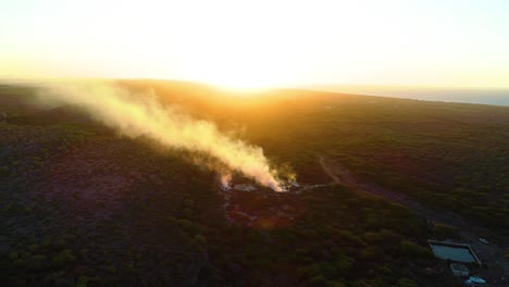 el avión no tripulado se eleva y se inclina hacia los pozos de humo en el norte de curacao al atardecer, quema industrial
