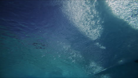 slow motion underwater view of waves forming in artificial wavepool, mesmerizing light and water patterns on the pool bottom