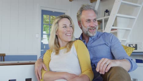 happy caucasian mature couple having fun and sitting in in living room