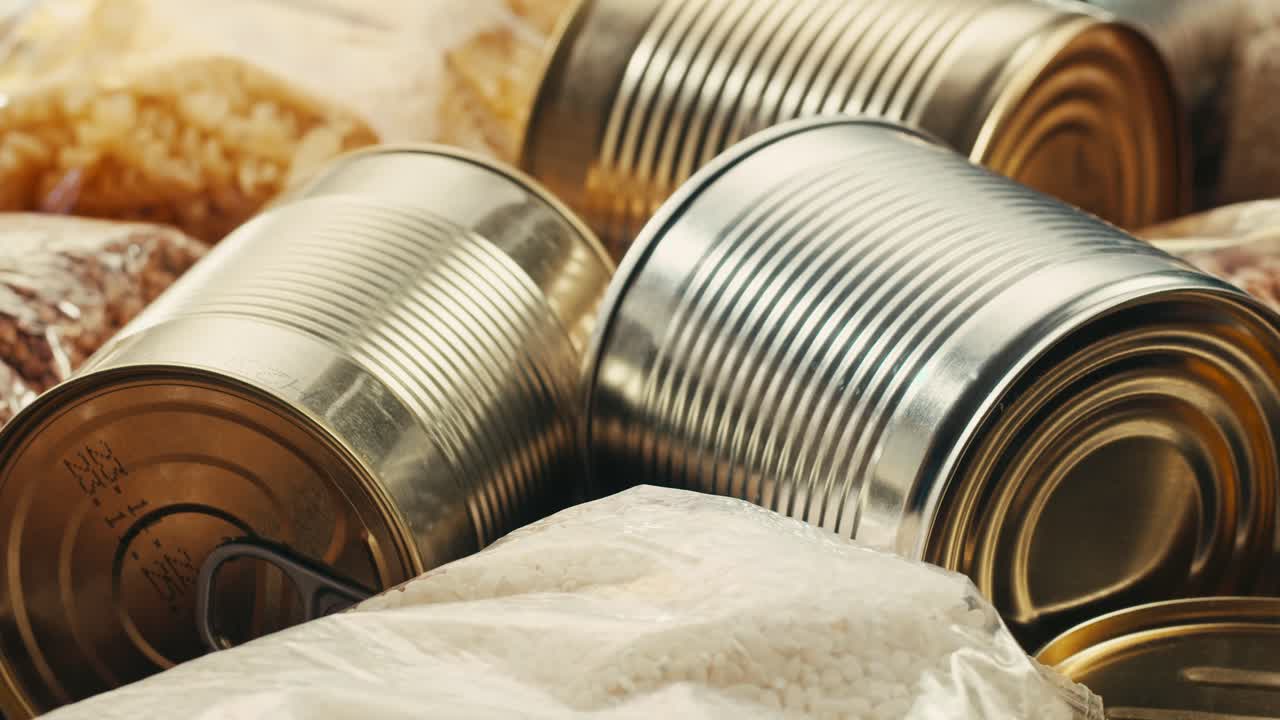 Canned cereals beans fish and vegetables, an assortment of processed foods, supermarket cart online shopping, delivery.