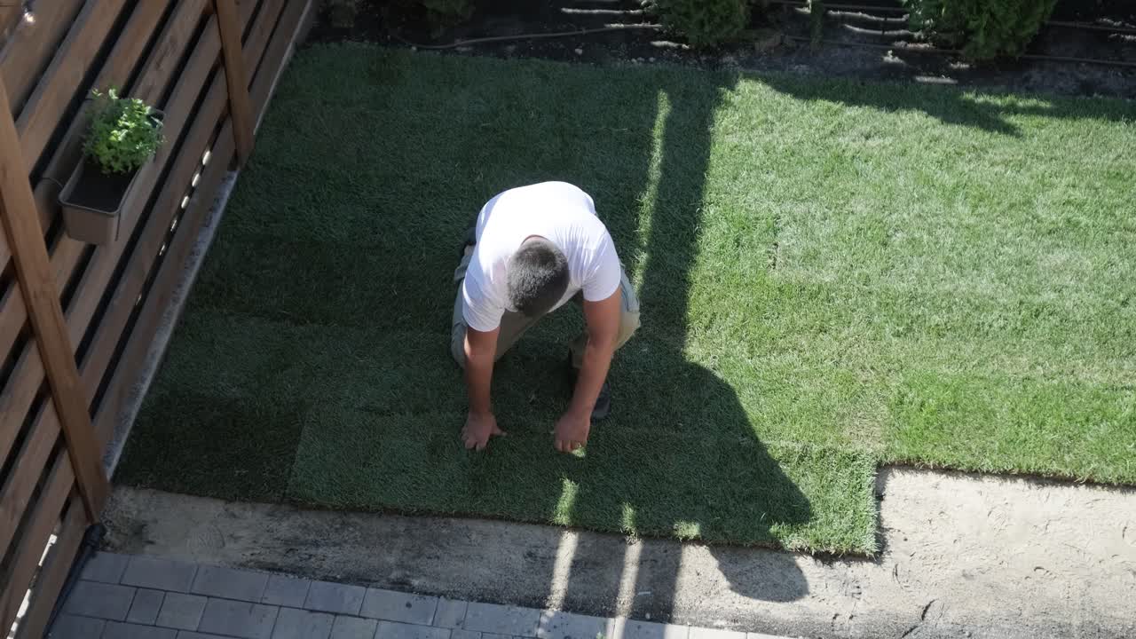 전문 정원사에 의해 설치 된 새로운 자연 잔디 잔디의 롤.