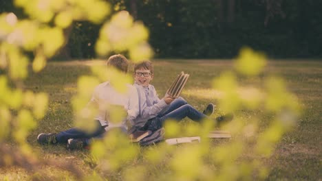 schoolboys do home task with books sitting in sunny garden