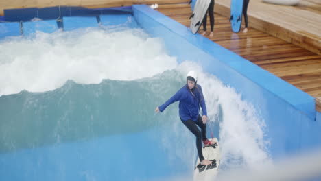 woman surfing in an indoor wave pool