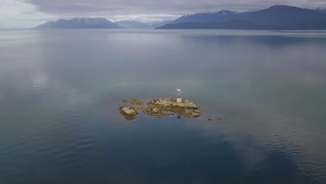 Vanderbilt-Reef-Aerial-View,-Surrounded-by-Ocean-with-Mountains-in-the-background