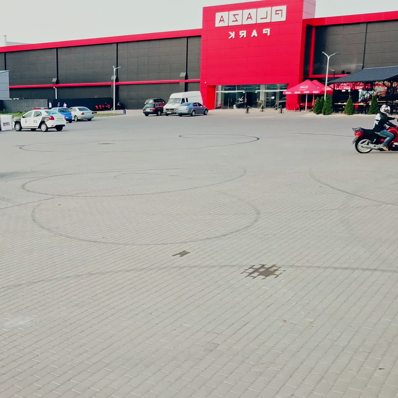 Two professional motobikers racing highspeed on a road in a circle way. Bikers on their motorcycles training riding on the background of city with modern buildings.