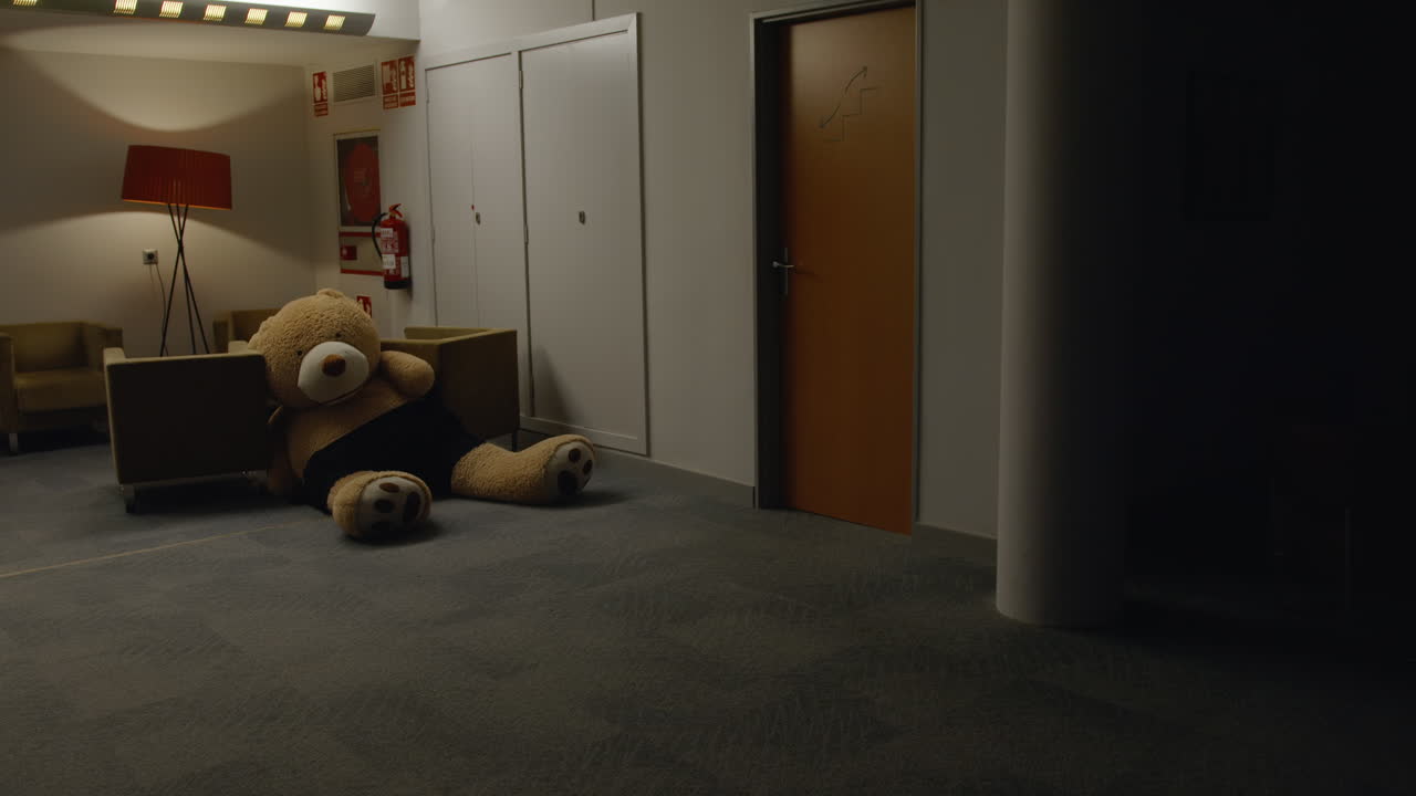 gran oso de peluche en un vestíbulo de la oficina por la noche