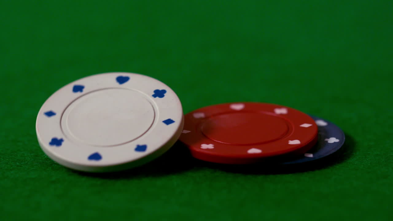 Casino chips falling on green table
