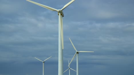 windmills against stormy sky with pan showing lateral stack movement