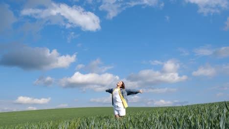 a woman standing in a field of wheat under a blue sky