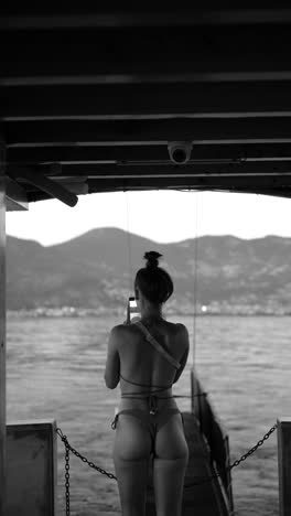 woman taking a photo on a pier, black and white