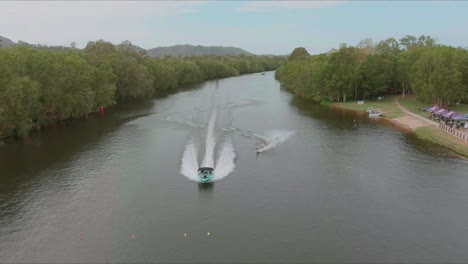 drone volando sobre el barco de remolque wakeboarder en el río