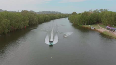 drone flying over the wakeboarder towing boat on the river