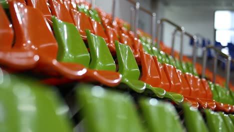 Low-angle-focus-racking-shot-of-green-and-orange-stadium-chairs