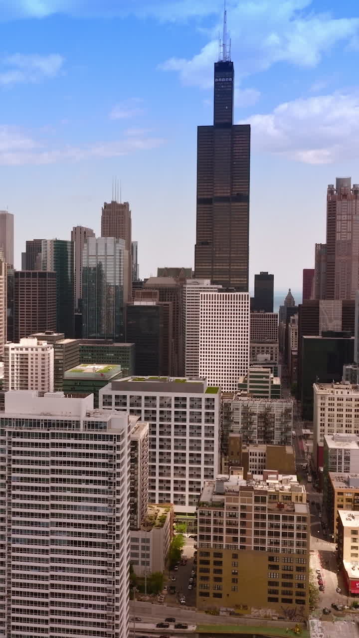 Multi-storied buildings and skyscrapers of majestic Chicago, Illinois. Vibrant city with busy traffic at daytime. Vertical video
