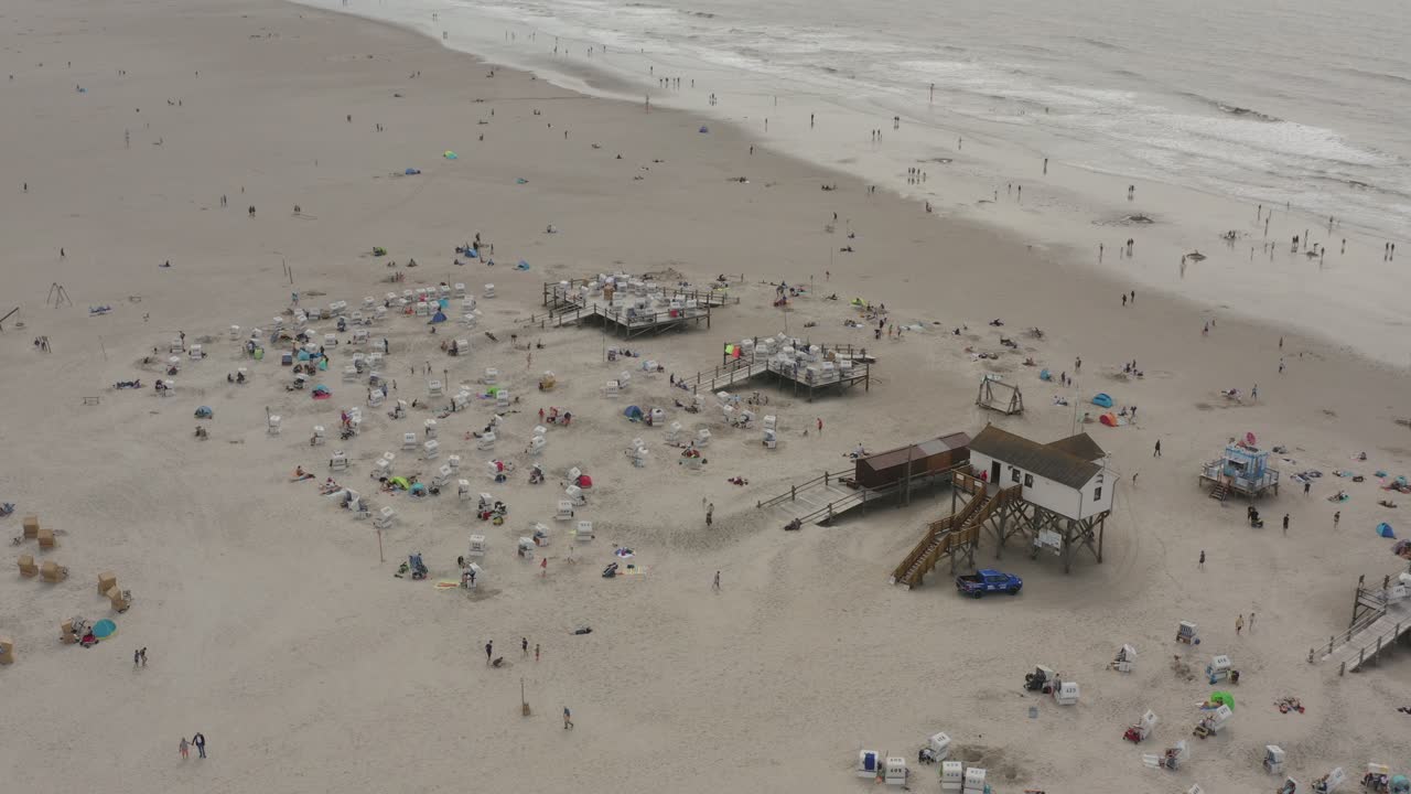 Drone - Aerial shot of the sandy beach with tourists and people in St. Peter Ording at the north sea, schleswig holstein, germany, 30p