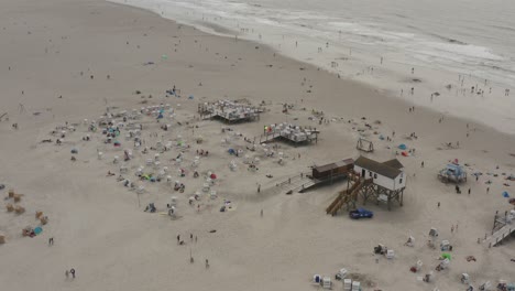 drone - aerial shot of the sandy beach with tourists and people in st. peter ording at the north sea, schleswig holstein, germany, 30p