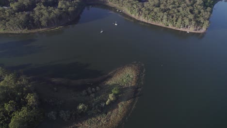 barcos en el lago tinaroo rodeados de un paisaje verde en yungaburra, queensland, australia