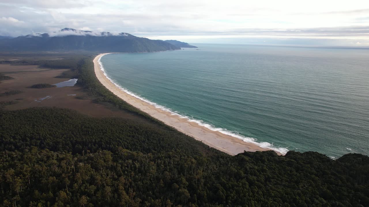 Long Sandy Beach With Turquoise Sea And Coastal Forest At Bruce Bay On West Coast Of New Zealand. aerial shot