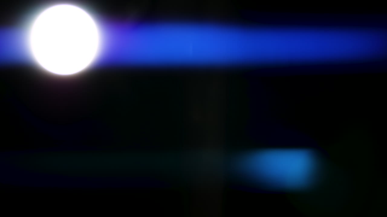 Bellissimi, sbalorditivi riflessi di luce e strisce anamorfiche blu girati su sfondo nero con lente anamorfica cinematografica di alta gamma, come sfondo, overlay di light leak o transizioni per editor
