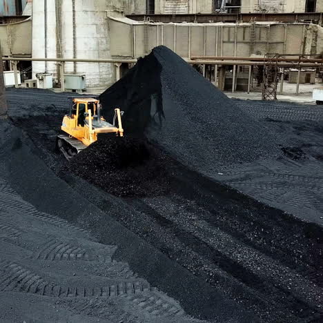 crawler bulldozer works on coal mines. extractive industry, anthracite. aerial view.