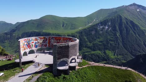 Cinematic-drone-shot-circling-around-an-ancient-monument-in-Georgia-in-front-of-beautiful-mountains