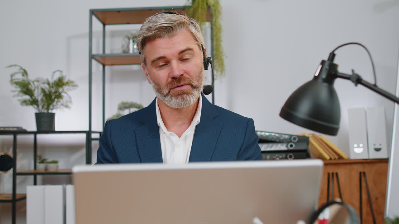 Forretningsmand arbejder på laptop med headset på, callcenter supportmedarbejder, serviceoperatør, kontorhotline