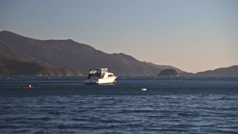 A-white-boat-is-moving-slowly-through-the-deep-blue-water