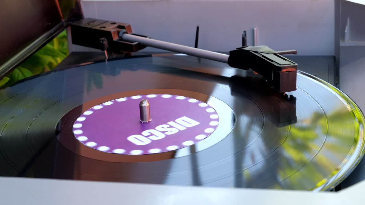 Antiquarian record player. Rotating plate and stylus with the needle close-up. Stylus arm and needle lowered on black vinyl record on a DJ turntable