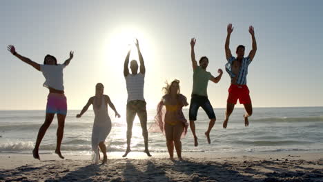 Verschiedene-Freunde-Springen-Freudig-An-Einem-Sonnigen-Strand