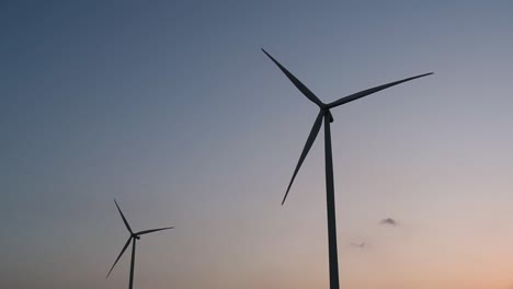 Silueta-De-Turbinas-Eólicas-Contra-El-Cielo-Azul-Durante-La-Puesta-De-Sol,-Energía-Alternativa-Limpia-En-Tailandia-Y-El-Sudeste-Asiático-Continental