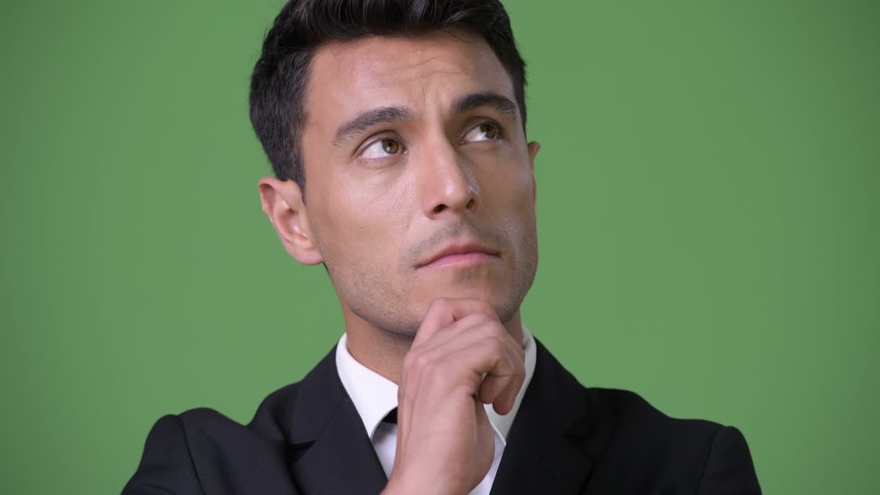 초록색 배경에 젊은 잘생긴 히스패닉 사업가