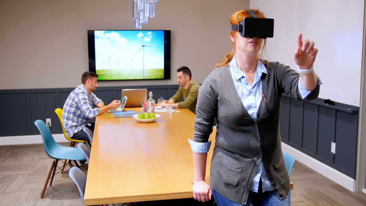 Executive using virtual reality headset while colleagues working in background 4k