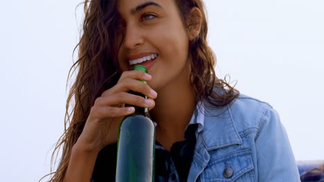 Couple-having-beer-while-sitting-on-car-bonnet-4k