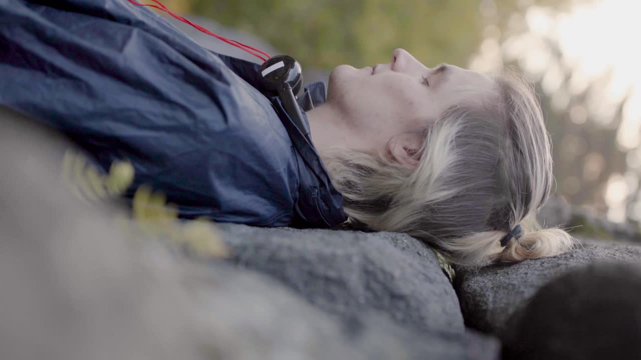 헤드폰을 들고 야외에서 휴식을 취하는 남자