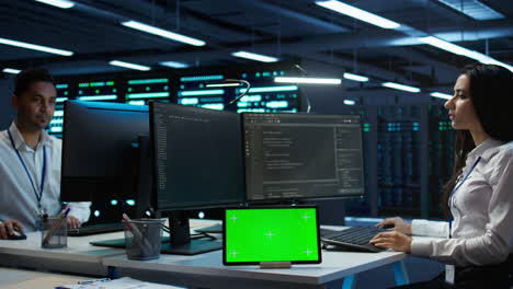 Woman-doing-maintenance-on-server-room-infrastructure-using-chroma-key-tablet