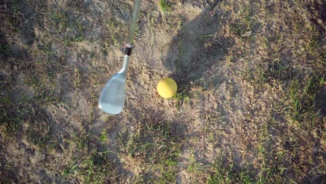 pelota de golf golpeada por golfista, vista desde arriba, tiro rápido con polvo en la calle